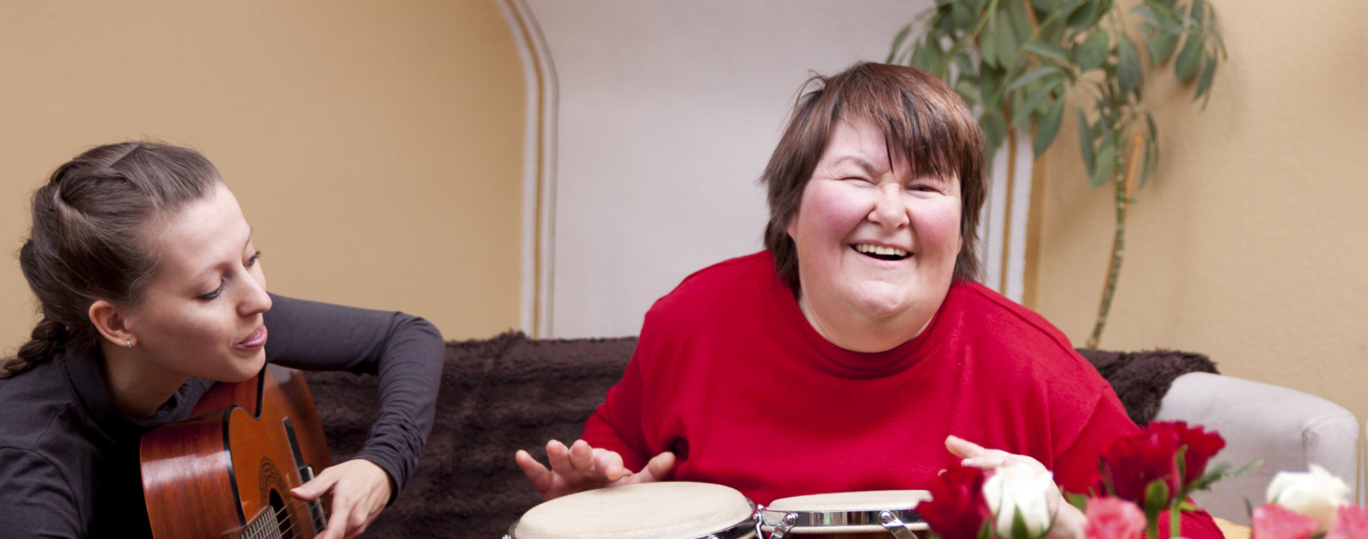 happy woman with disability playing instrument wtih woman